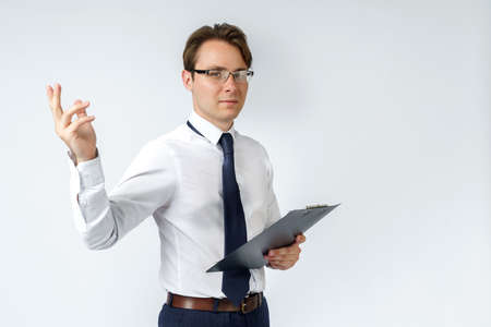 Portrait of a businessman who shows a hand gesture and holds a tablet. White background. Business and finance conceptの写真素材