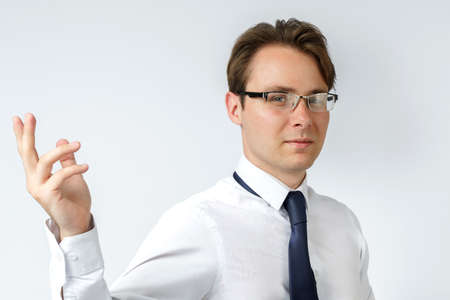 Portrait of a businessman who makes a hand gesture to the side. White background. Business and finance conceptの写真素材