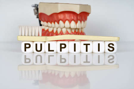 Medical, dental concept. The text is written on the cubes - PULPITIS. In the background is a model...