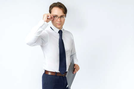 Portrait of a businessman adjusting his glasses. White background. Business and finance concept