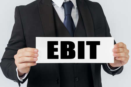 Business and finance concept. A businessman holds a sign in his hands which says EBITの写真素材