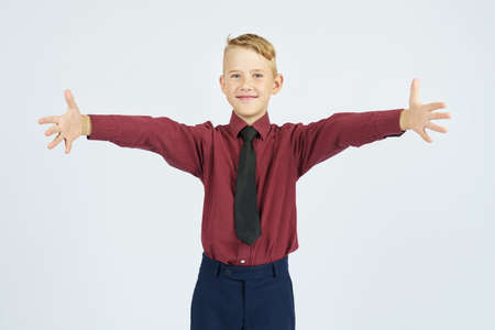 Portrait of a schoolboy with open arms who smiles. Education concept.