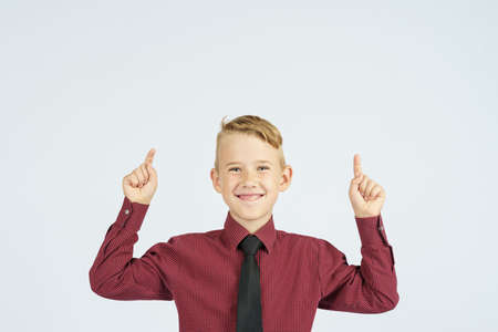 A portrait of a schoolboy showing thumbs up. Education concept.
