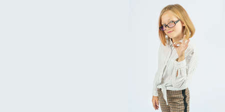 Teenager girl with glasses expresses emotions, showing a gesture - ok hand. Isolated background. Education concept.の写真素材