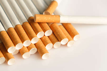 Medicine concept. Cigarettes with a yellow filter lie on a white surface