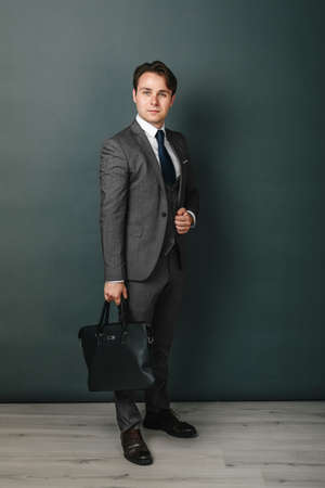 Business and finance concept. Portrait of a businessman who is holding a briefcase. Light backgroundの写真素材