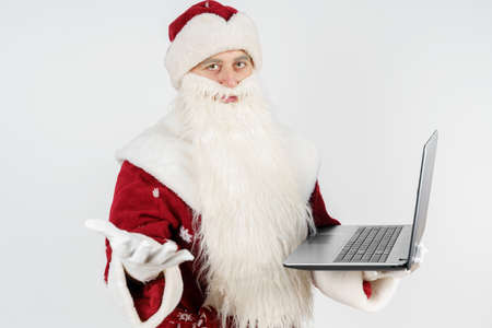 Christmas and New Year concept. Santa Claus sits at his desk and works at the computer.