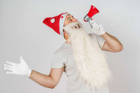 Christmas and New Years concept. Santa Claus announces in a megaphone. Isolated background.の写真素材