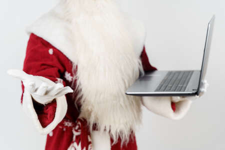 Christmas and New Year concept. Santa Claus sits at his desk and works at the computer.の写真素材