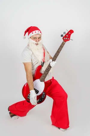 Holidays and christmas concept. Santa Claus plays the guitar. Isolated on whiteの写真素材