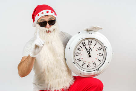 Holidays and Christmas concepts. Santa Claus shows the time remaining before Christmas on the clock....