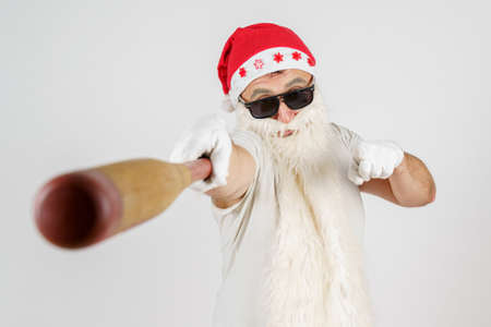Holidays and christmas concept. Santa Claus with a baseball bat in his hands. Isolated on whiteの写真素材
