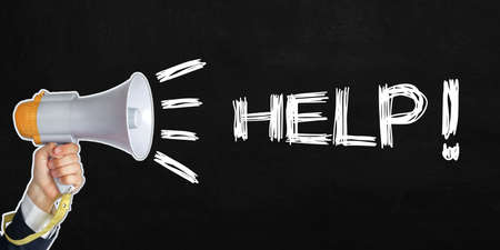 A businessman speaks into a loudspeaker, next to the text - HELP. No face visible. Black backgroundの写真素材