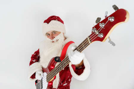 Holidays and christmas concept. Santa Claus plays the guitar. Isolated on whiteの写真素材