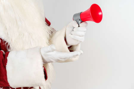 New Year and Christmas concept. Santa Claus holds a megaphone in his hands. Isolated on light...
