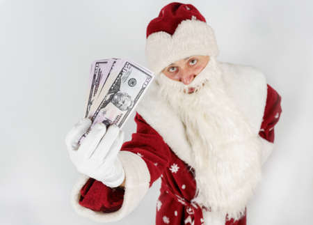 New Year and Christmas concept. Santa Claus holds money in his hands. Isolated on light backgroundの写真素材