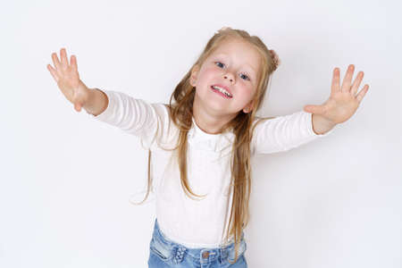 Children concept. Girl in different directions up her hands, looking at the camera. Isolated over...