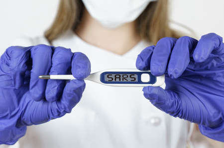 Medicine and health concept. The doctor holds a thermometer in his hands, on the electronic screen...