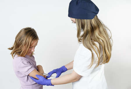 Medicine and health concept. A female doctor injects a teenage girl in the arm. Isolated on white