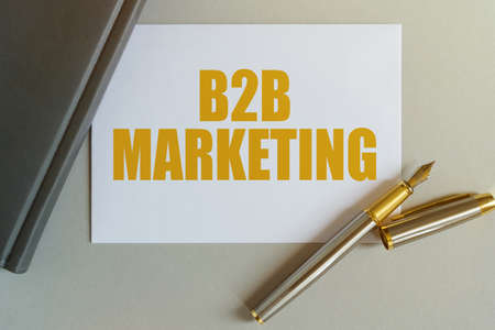 Business and finance concept. On the table are a notebook, a pen and a business card with the inscription - B2B MARKETINGの写真素材