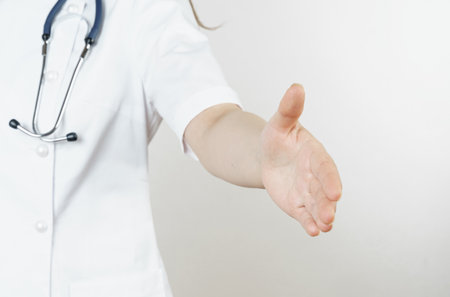 Medicine and health concept. Doctor woman welcomes with her hand. Isolated on white background.の写真素材