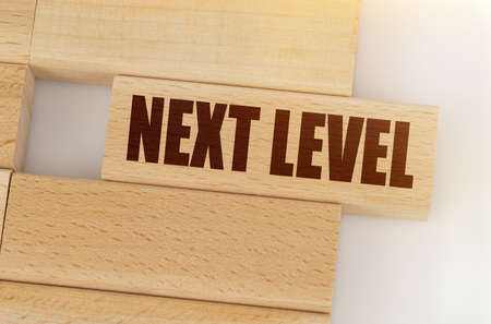 Business and finance concept. There is a wooden block on the table, on one block it is written - NEXT LEVELの写真素材