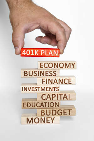 Business concept. Businessman hand sets on a tower with business words red wooden block with the...