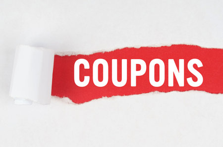 Business and finance. Behind torn white paper on a red background, the text - COUPONSの写真素材
