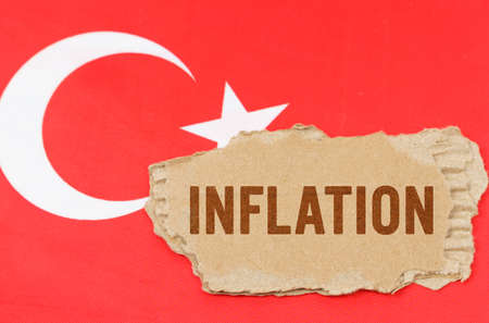 Business and finance concept. Against the background of the flag of Turkey lies cardboard with the inscription - inflationの写真素材