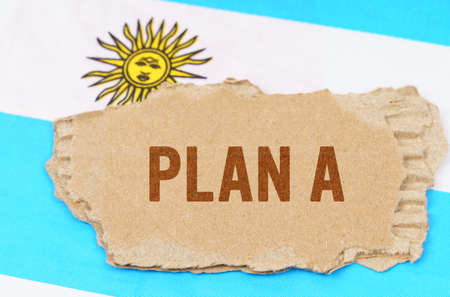 Business and finance concept. Against the background of the flag of Argentina lies cardboard with...
