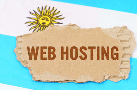 Business and finance concept. Against the background of the flag of Argentina lies cardboard with the inscription - Web Hostingの写真素材