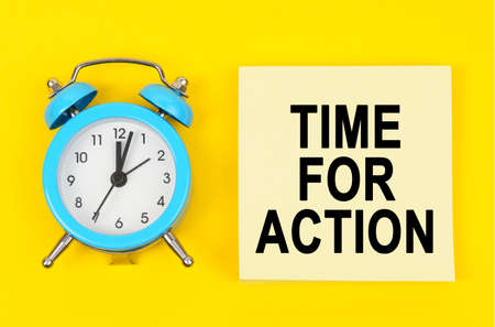 Business and finance concept. On a yellow background lie a clock and a sticker sheet with the...