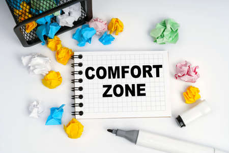 Business and finance concept. On the table is a basket, multi-colored paper and a notebook with the inscription - Comfort Zoneの写真素材