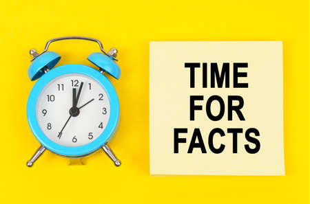 Business and finance concept. On a yellow background lie a clock and a sticker sheet with the...