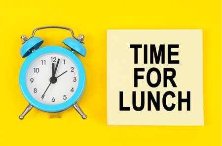 Business and finance concept. On a yellow background lie a clock and a sticker sheet with the...