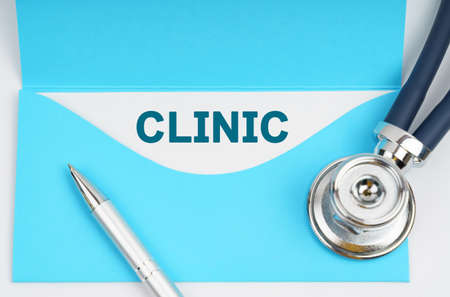 Medicine and health concept. There is a stethoscope on the table, an envelope with paper on which it is written - CLINICの写真素材