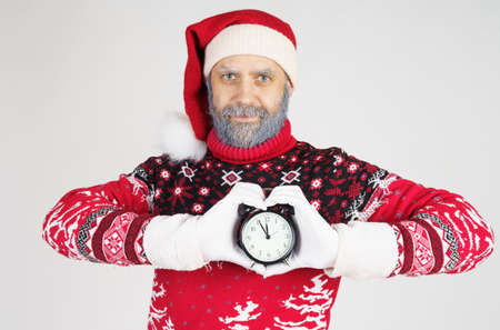 Holiday and Christmas concept. Santa Claus holds a watch in his hands. The palms are folded in the...