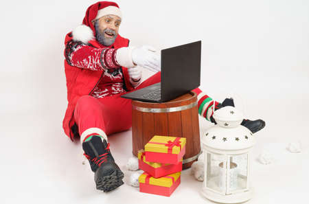 Holiday and Christmas concept. Santa Claus communicates online through a laptop.