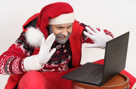 Holiday and Christmas concept. Santa Claus communicates online through a laptop.