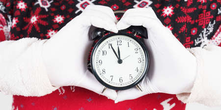 Holiday and Christmas concept. Santa Claus holds a watch in his hands. The palms are folded in the...