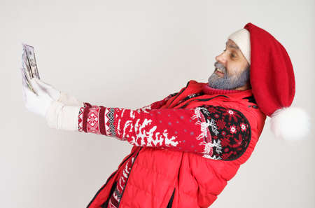 New Year and Christmas concept. Santa Claus is holding money in his hands, feeling joy.