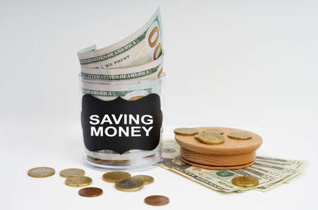 Business and finance concept. There is a bank with money on the table, it says - SAVING MONEYの写真素材