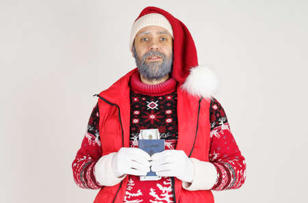 New Year and Christmas concept. Santa Claus is holding money and a passport.の写真素材