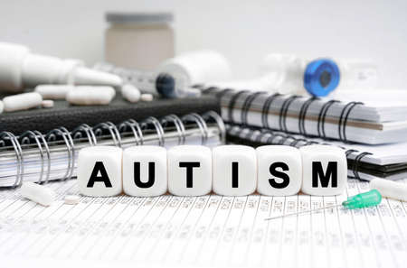 Medicine concept. On the table are diaries, medicines and cubes with the inscription - AUTISMの写真素材