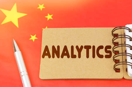 National economy concept. On the flag of China lies a notebook with the inscription - analytics