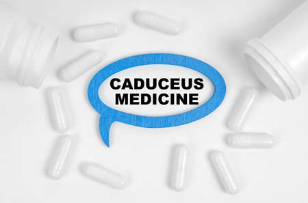 Medicine concept. On the table there are pills and a blue plaque inside which the inscription -...