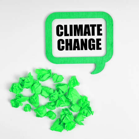 Ecology concept. On a white background, green crumpled pieces of paper and a sign inside which the inscription - Climate Changeの写真素材