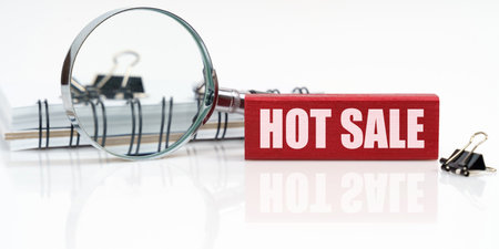 Business concept. On the table is a notebook, a magnifying glass and a tablet with the inscription - HOT SALEの写真素材