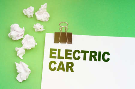 Ecology concept. On a green background, crumpled paper and a sheet with the inscription - electric...