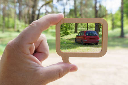 Ecology concept. Wooden frame - a pointer inside which a car in the forestの写真素材